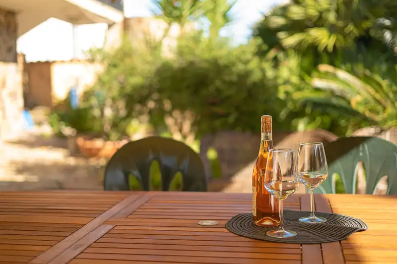 Bottiglia di benvenuto e calici sul tavolo del giardino